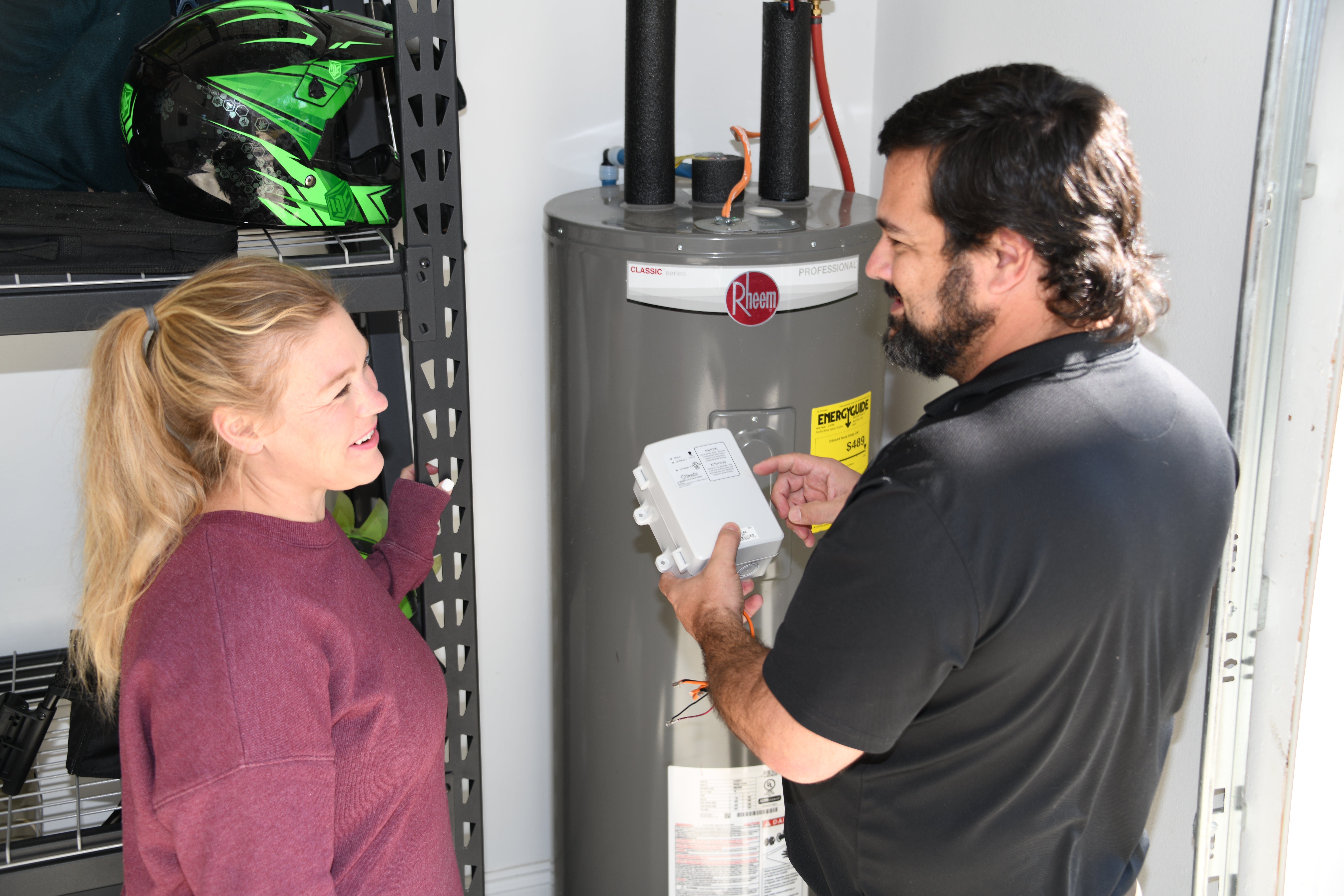 Above: A CHELCO energy advisor (right) speaks with a member in their home about a LCS switch being installed on her hot water heater